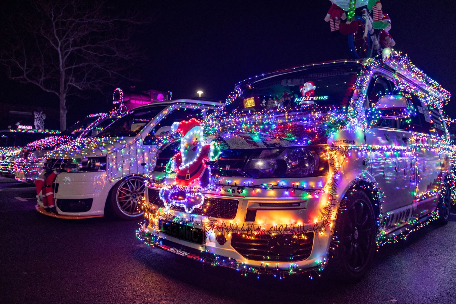 A line-up of VW vans decorated with Christmas lights at the Vee Dubs Christmas Cruz Weston-super-Mare